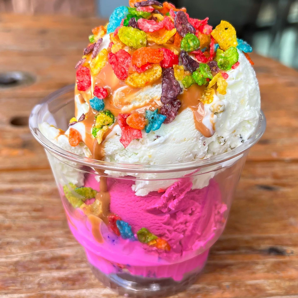 La Paleta's vibrant pink and white ice cream sundae, topped with colorful cereal and caramel drizzle.